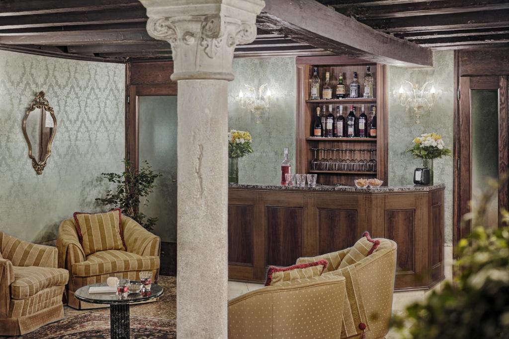 a lobby with a bar with chairs and a table at Hotel Pausania in Venice