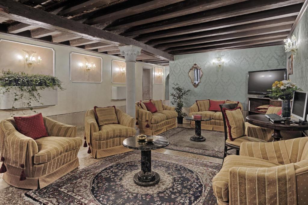 a living room with couches and chairs and a television at Hotel Pausania in Venice
