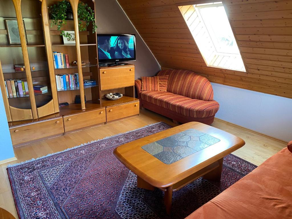 a living room with a couch and a table and a tv at Wohnung nahe Jacobs Uni und Knoops Park in Bremen