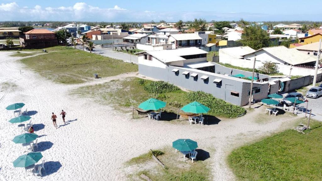 una vista aérea de un complejo con sombrillas en la playa en Mágica Suites, en Cabo Frío