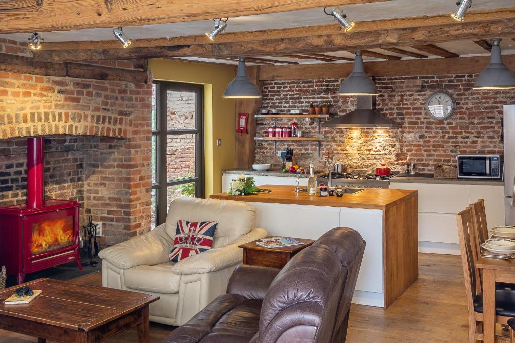 a kitchen and living room with a brick wall at Wonderful wooden beamed 17th century retreat - White Lion Cottage in Hadleigh