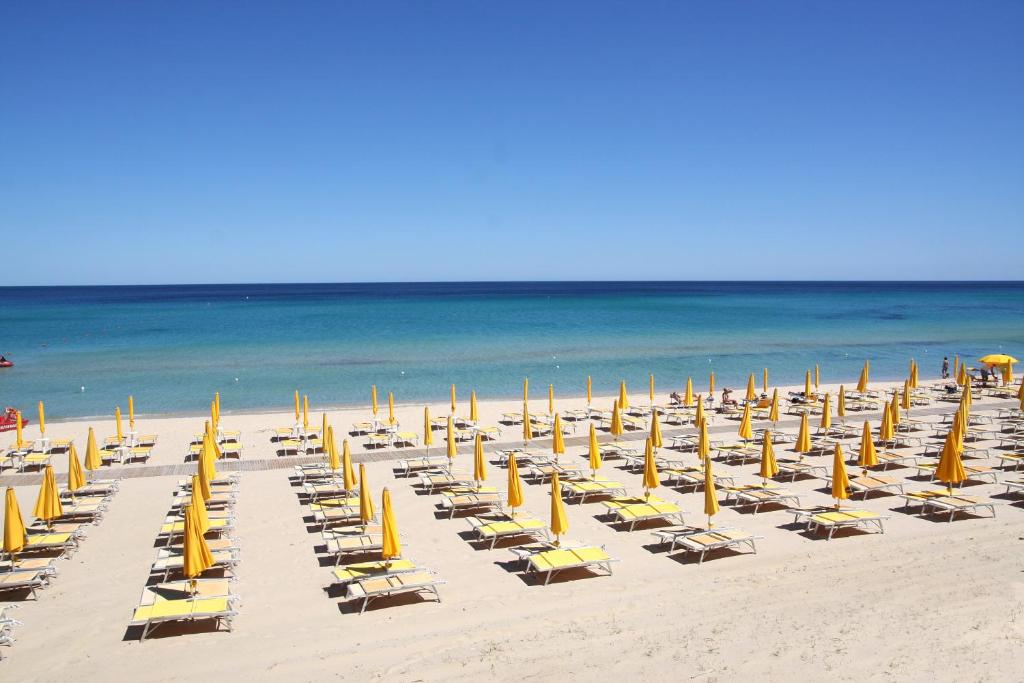 un gruppo di sedie e ombrelloni in spiaggia di TH Costa Rei - Free Beach Resort a Monte Nai