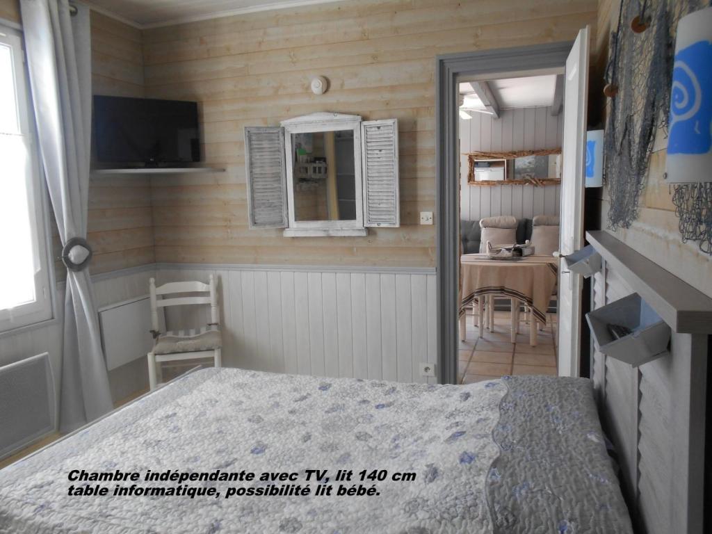 1 dormitorio con cama, mesa y espejo en ILE DE RE, LA DANAE avec VELOS, WIFI, COIN CUISINE, LINGE, PARKING gratuit en Saint-Martin-de-Ré