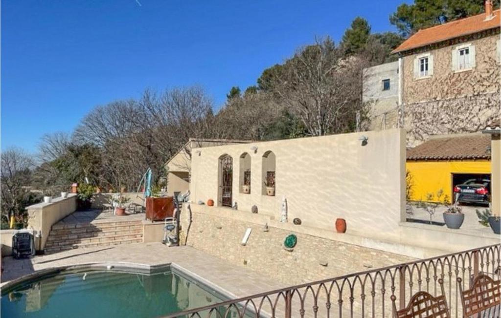 une maison avec une piscine à côté d'un bâtiment dans l'établissement Lovely Home In La Roque-Sur-Pernes, à La Roque-sur-Pernes