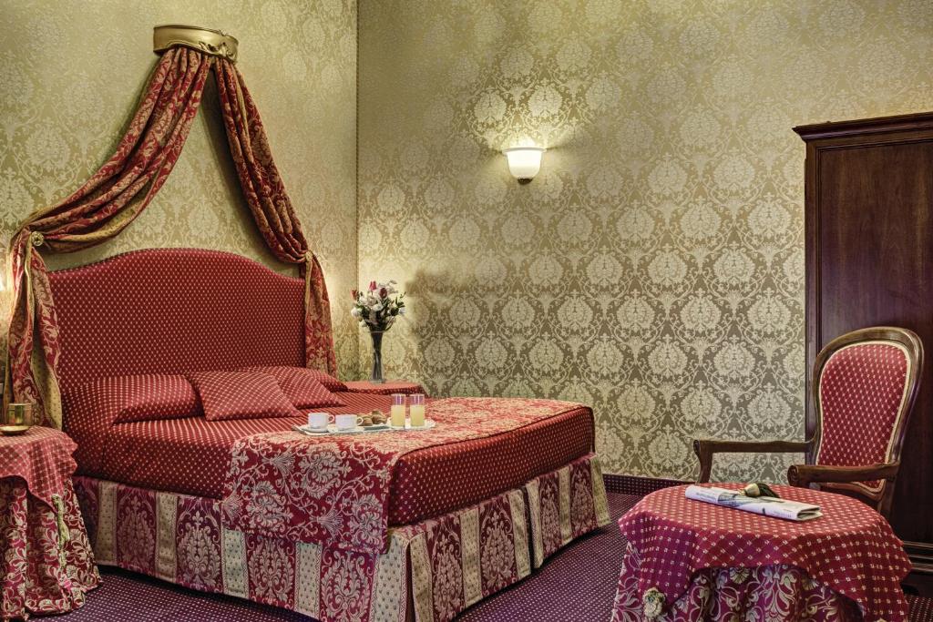 a bedroom with a bed and a table and chairs at Hotel Pausania in Venice