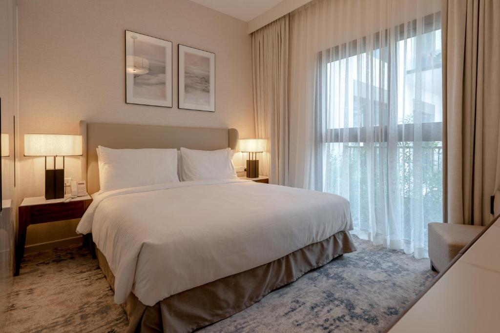 1 dormitorio con cama grande y ventana grande en Alnoon at Address Beach Resort Fujairah, en Sharm
