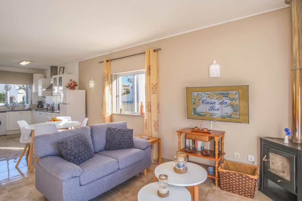 un salon avec un canapé bleu et une cheminée dans l'établissement Casa da Tia, à Luz