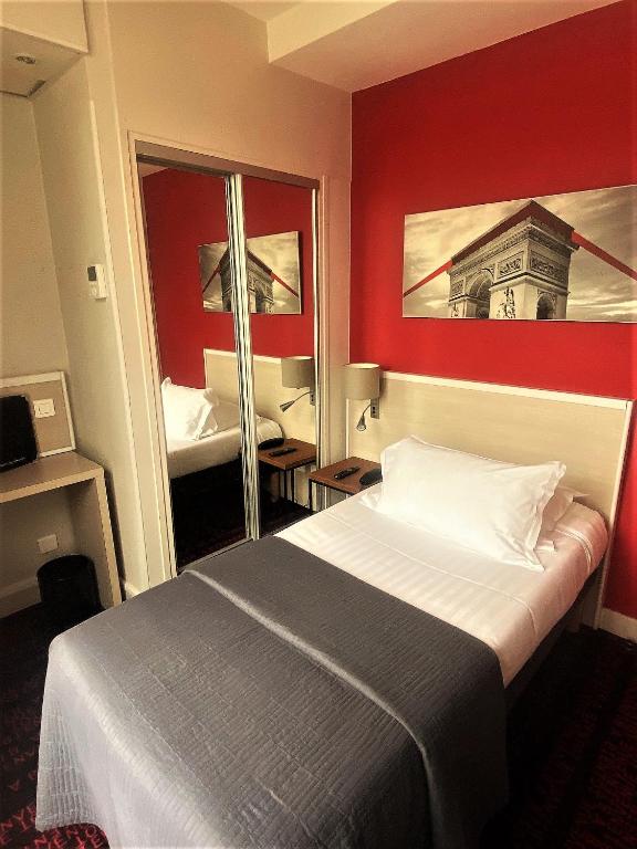 ein Hotelzimmer mit einem Bett und einem Spiegel in der Unterkunft Hotel Le Richemont in Paris