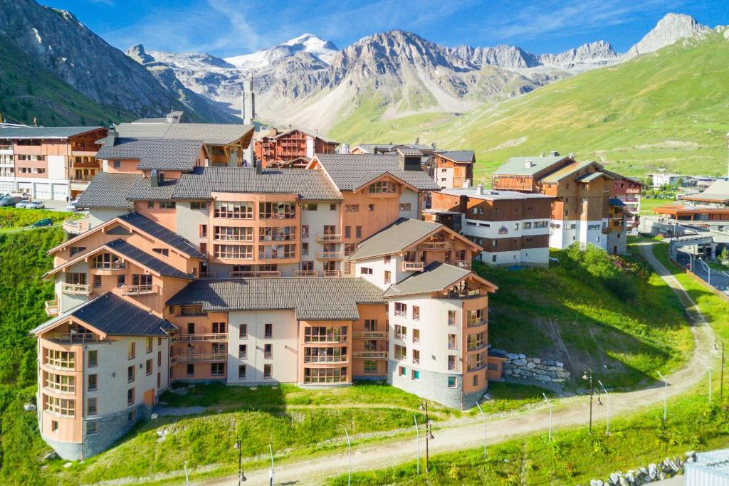 an apartment complex on a hill with mountains in the background at Le Taos in Tignes