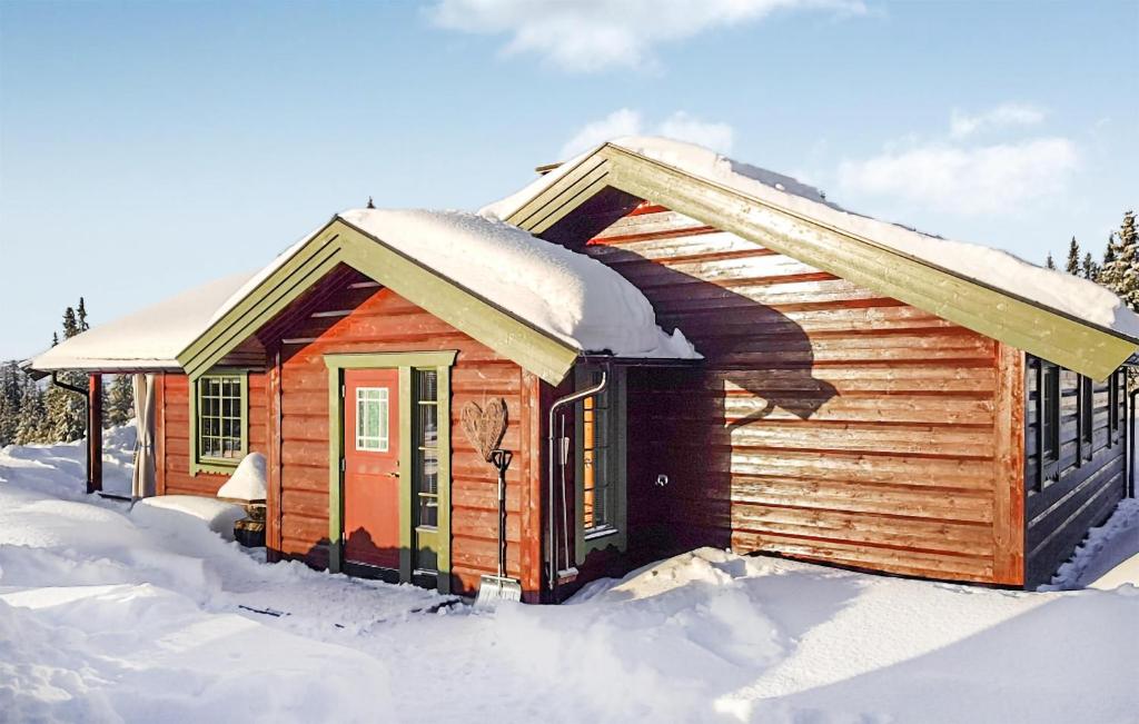 a cabin covered in snow in the snow at Awesome Home In Ulnes With Sauna And 3 Bedrooms in Ulnes