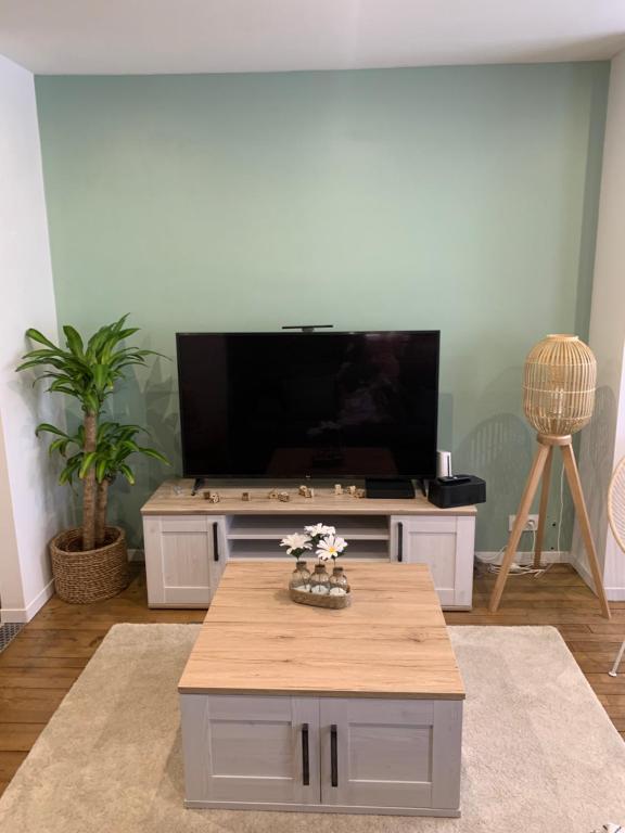 un salon avec une télévision et une table basse dans l'établissement Appartement centre-ville rénové 6/8 personnes, à Gérardmer