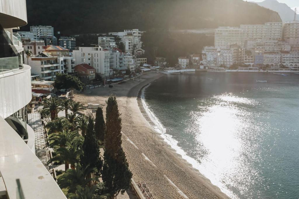 a view of a beach with palm trees and buildings at Beachfront luxury apartment in Budva