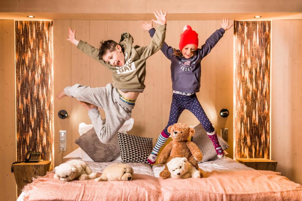 two children jumping in the air on a bed at Le Taos in Tignes