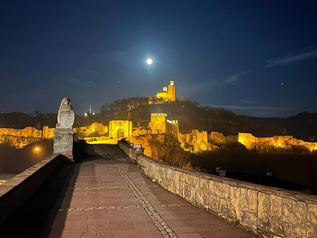 una vista di un castello di notte con la luna di HOTEL BOLYARI a Veliko Tŭrnovo