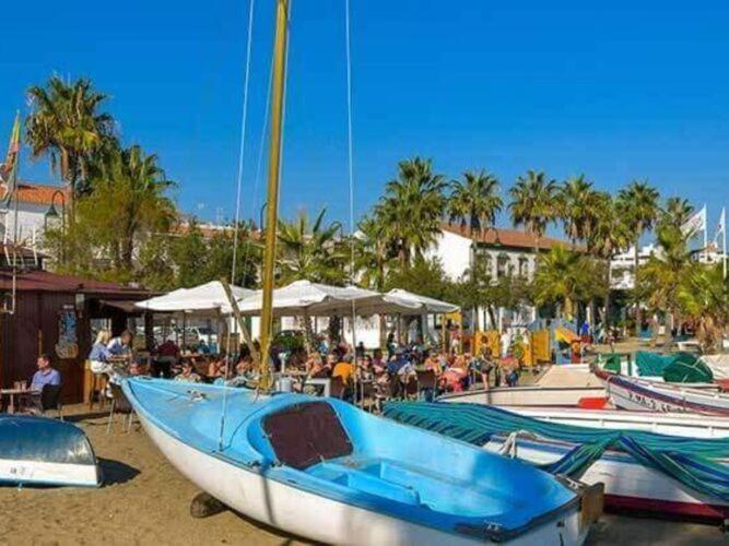 un barco azul sentado en la arena en una playa en Apartment La Cala Boulevard en La Cala de Mijas