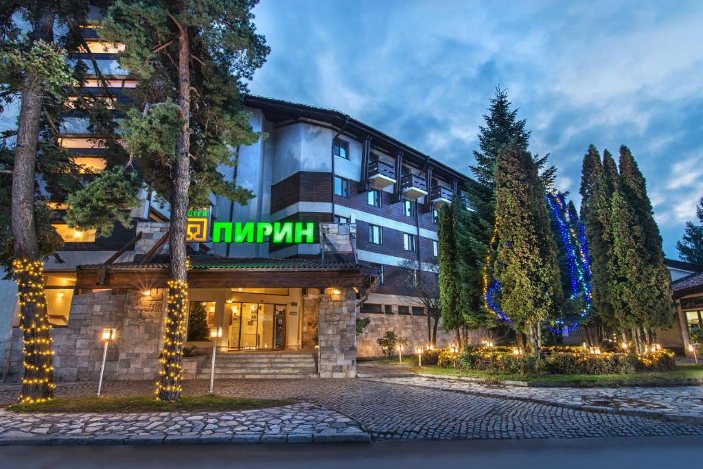 a hotel with a sign on the front of it at Hotel Pirin in Bansko