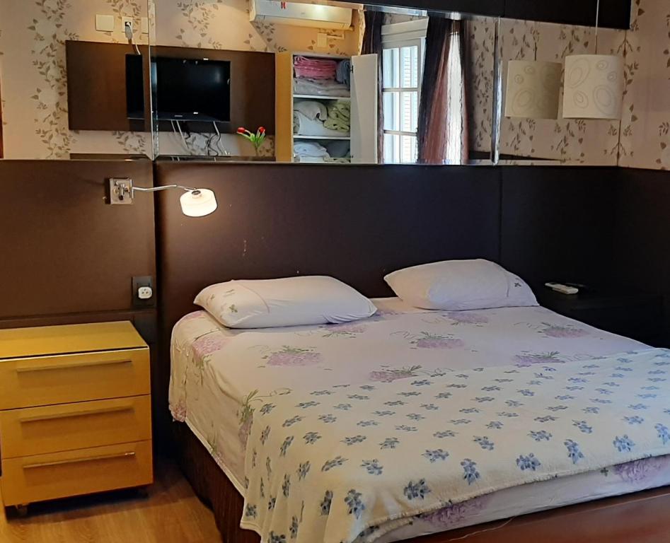 a small bedroom with a bed and a television at RESIDENCIAL VICENZA in Gramado