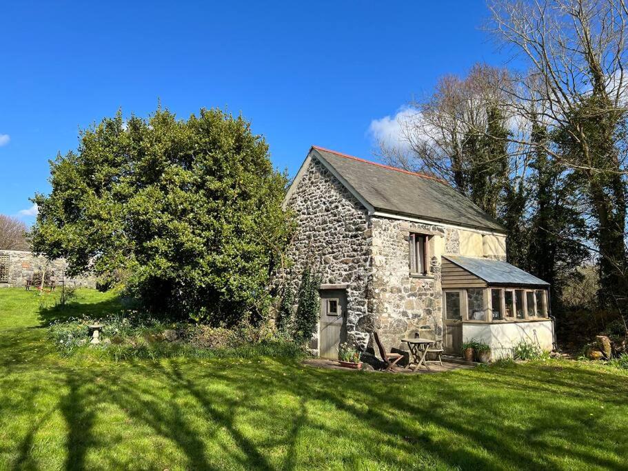 an old stone house in a field of grass at The Studio, Trelugga in Helston