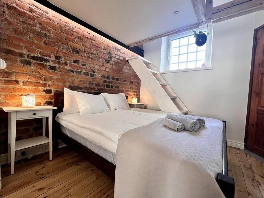 a bedroom with two beds and a brick wall at Uniikki&Upea Helmi ydinkeskustassa in Tampere