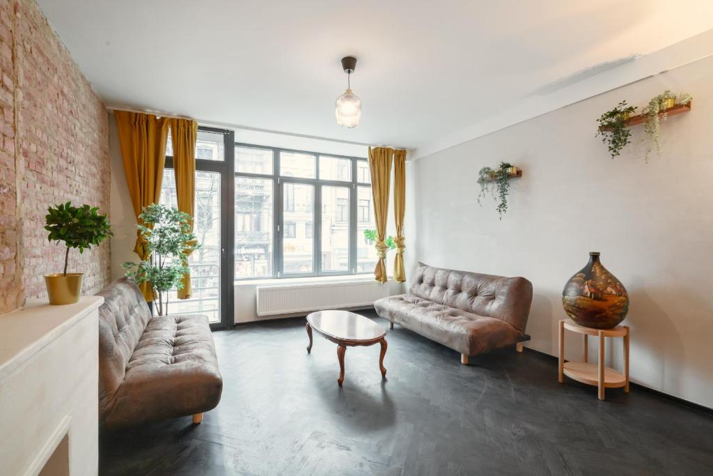 a living room with two couches and a table at Charming and Spacious Antwerp City Center Apartments in Antwerp