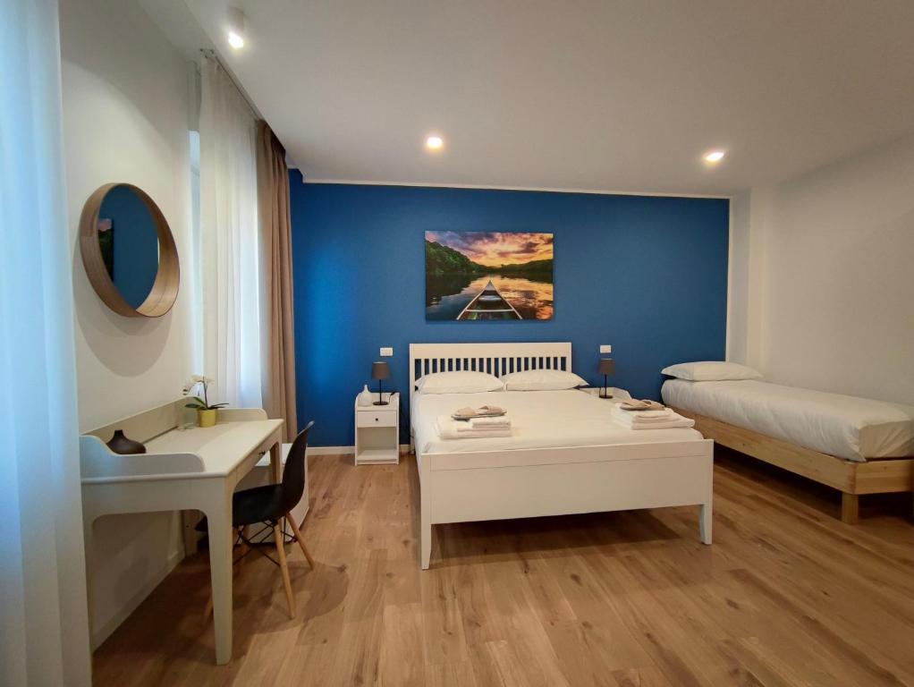 1 dormitorio con cama, escritorio, cama y mesa en La residenza del viale, en Treviglio