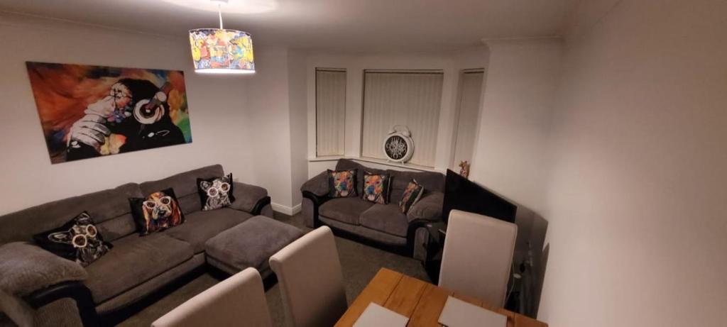 een woonkamer met een bank en een tafel bij Cozy Comforts 2 bed apartment Central Warrington in Warrington
