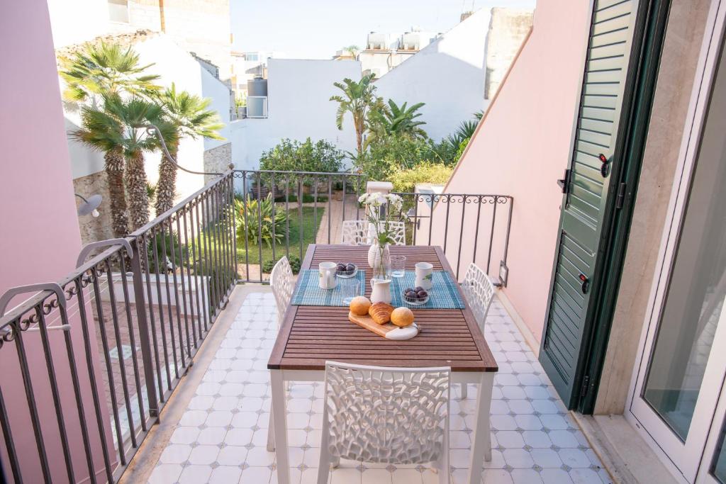 a table on the balcony of a house at Talè Talè Apartment in Marina di Ragusa