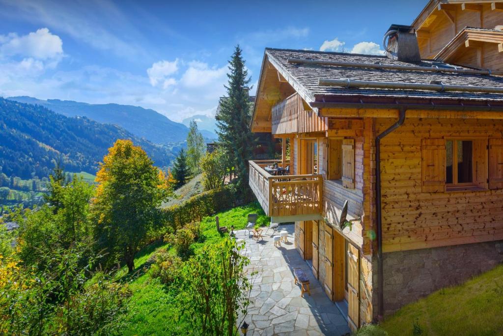 a house on a hill with a view at Chalet Aravista - OVO Network in Le Grand-Bornand