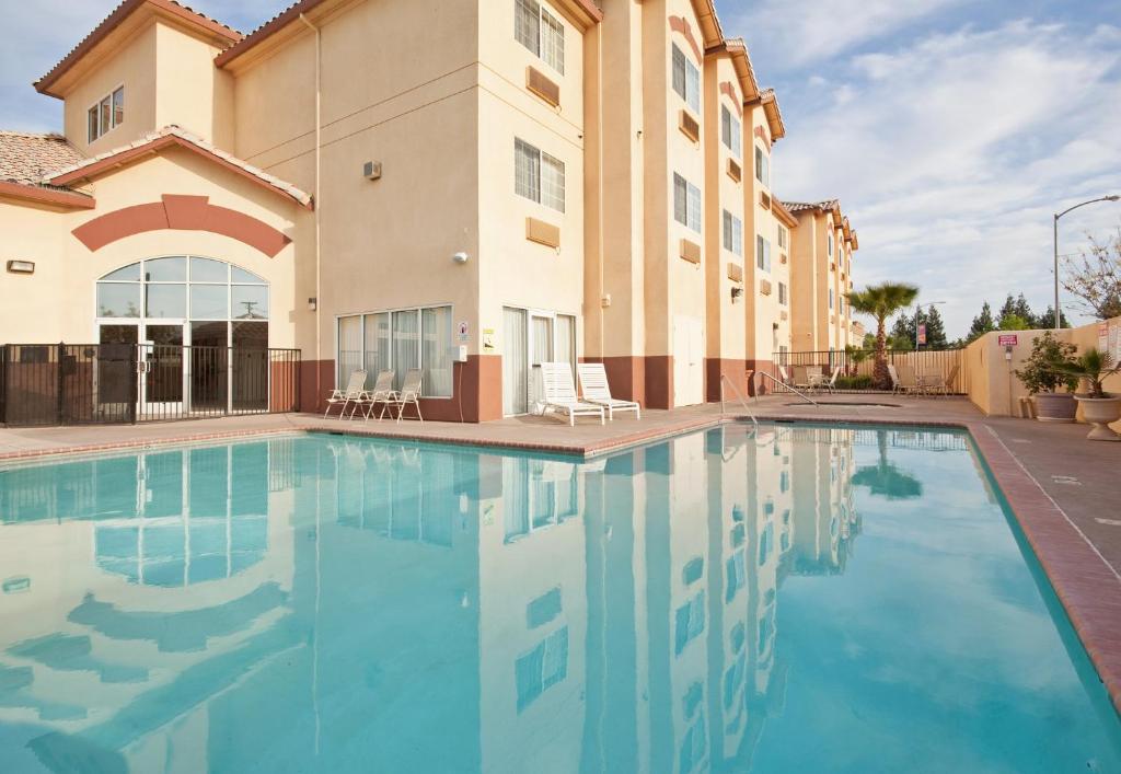 a swimming pool in front of a villa at Holiday Inn Express Madera, an IHG Hotel in Madera