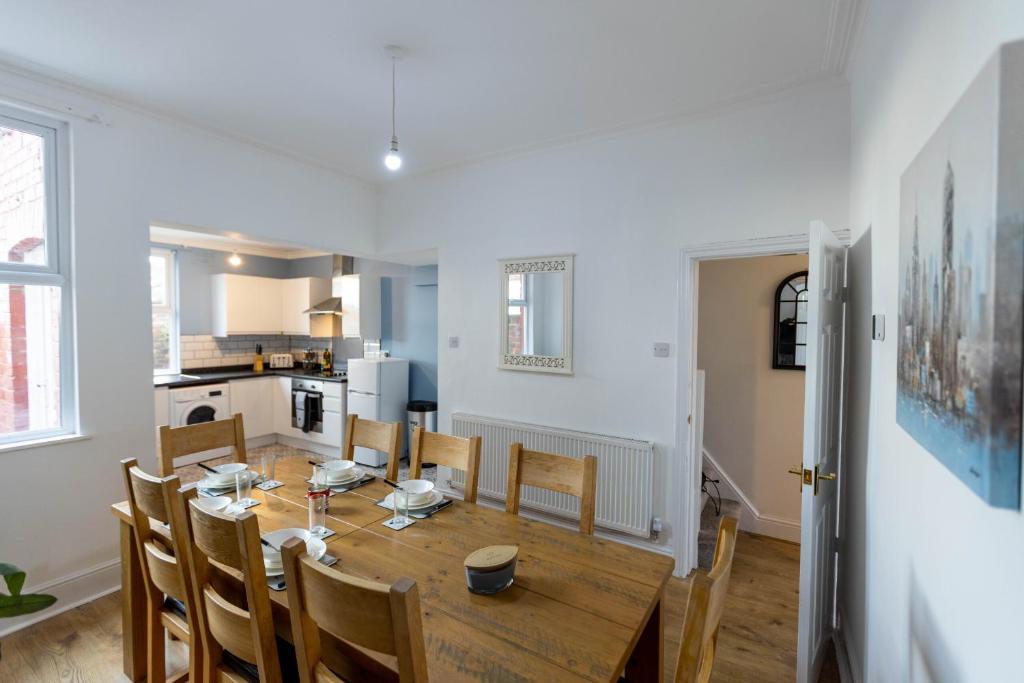 a kitchen and dining room with a wooden table and chairs at Luxury Stays in Birkenhead