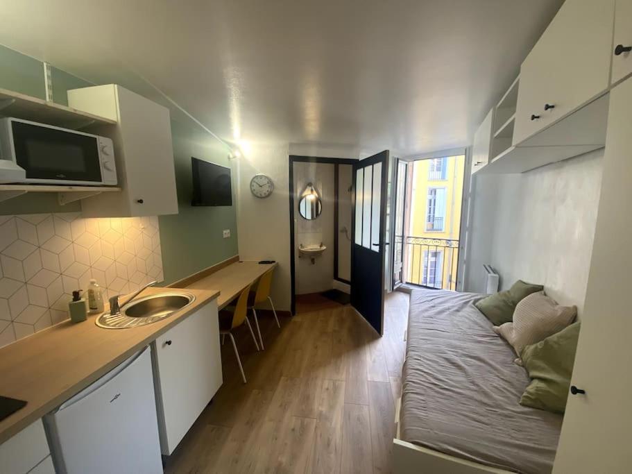 a small kitchen with a bed and a sink in a room at Studio en plein centre historique de perpignan in Perpignan