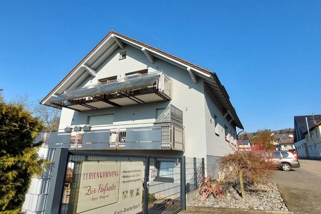 ein weißes Gebäude mit einem Balkon an der Seite in der Unterkunft 10 Personen Ferienwohnung i. Odw in Mörlenbach