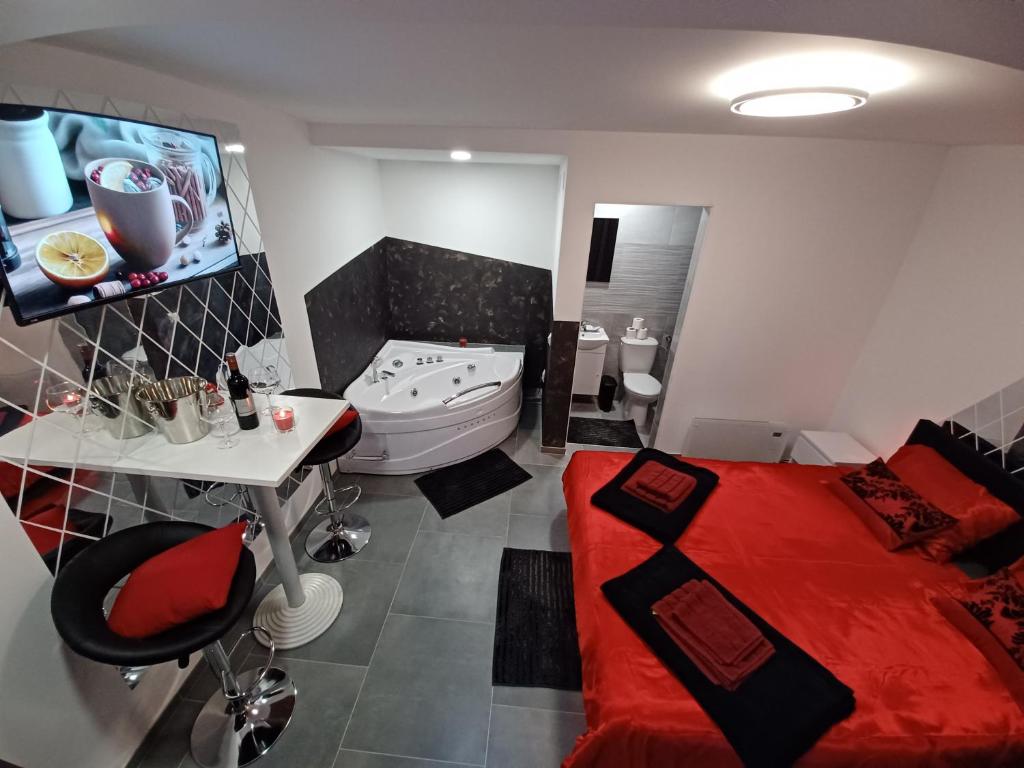 a bathroom with a red bed and a bath tub at Aquas AP in Petrijanec