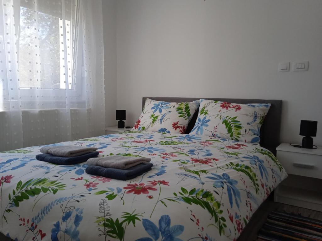 a bed with a floral bedspread with two pillows on it at Seoski turizam Stari mlin na Korani room 2 in Karlovac