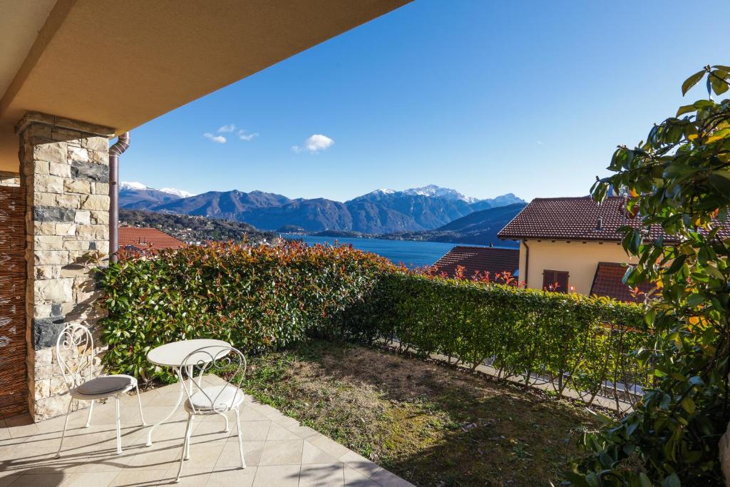 a patio with two chairs and a view of the water at Bellavista Apartments in Lenno