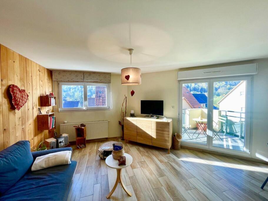 un salon avec un canapé bleu et une table dans l'établissement Au nid de cigogne avec garage à Kaysersberg, à Kaysersberg