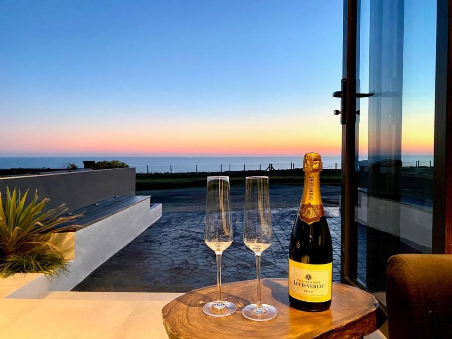 a bottle of wine and two wine glasses on a table at Seaview Stay in Peacehaven
