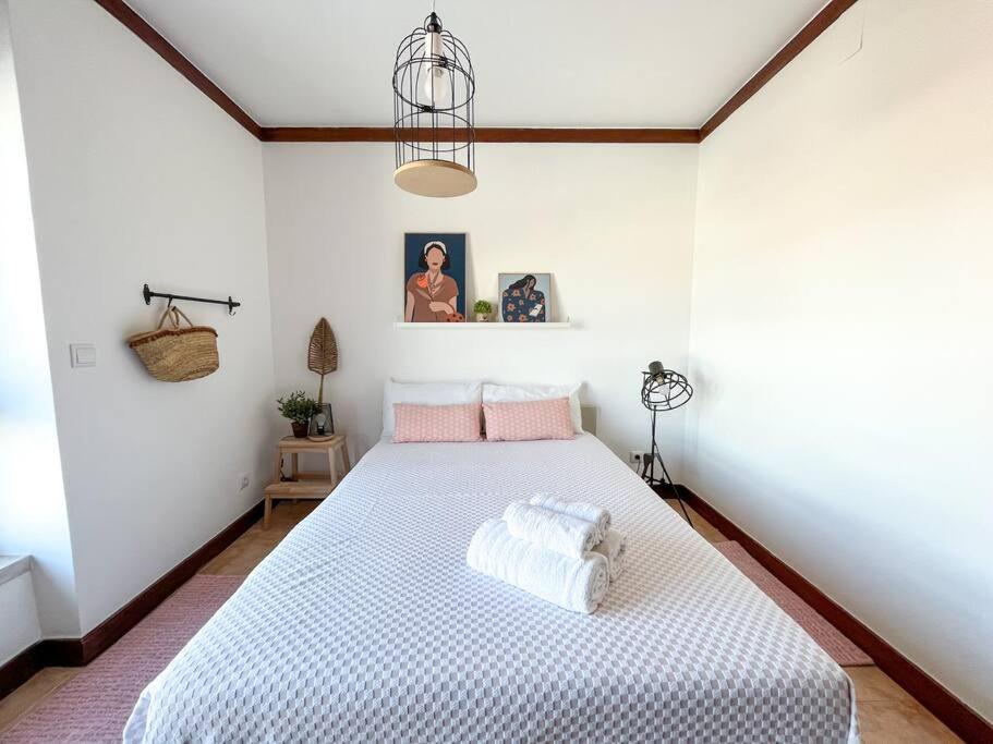 - une chambre avec un grand lit blanc et des oreillers roses dans l'établissement Esplanada - Zona Central-Estacionamento e Wifi Gratuito-Perto Praias, à Setúbal