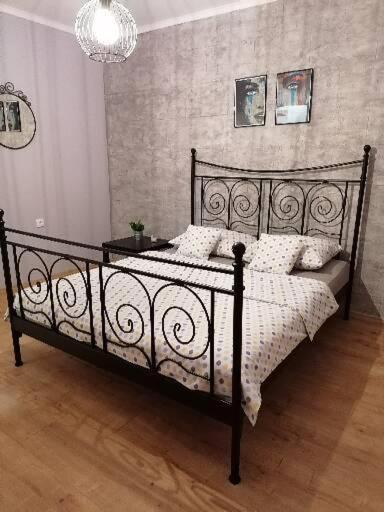 um quarto com uma cama preta e almofadas brancas em Stan na dan em Pozarevac