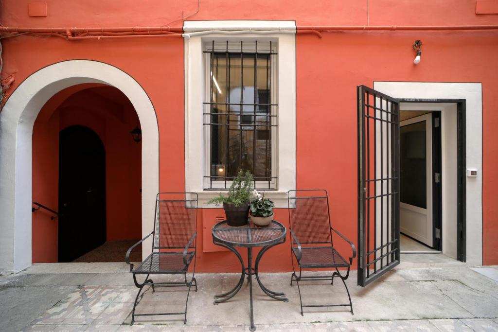 uma mesa e duas cadeiras em frente a um edifício em Brescia musei em Brescia