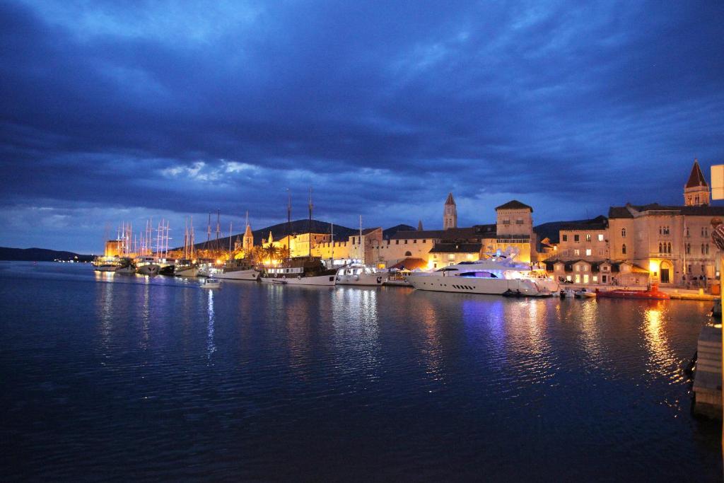 um porto à noite com barcos na água em Apartments Villa Macola em Trogir