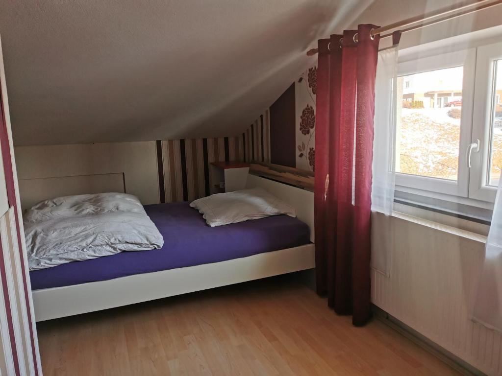 een kleine slaapkamer met een bed en een raam bij Haus mit schöner Aussicht WG in Münsingen