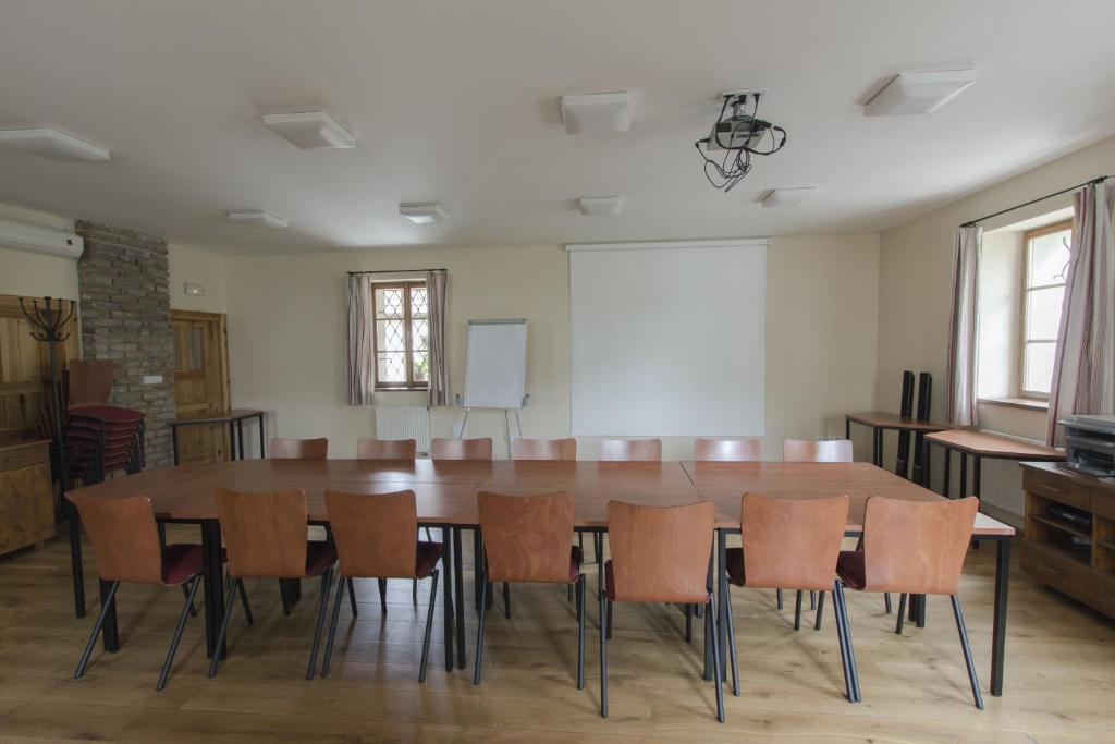 sala konferencyjna z dużym drewnianym stołem i krzesłami w obiekcie Penzion Ve stoleti w mieście Loděnice