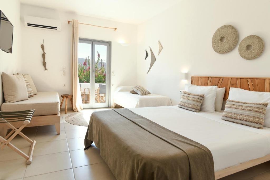 a bedroom with a bed and a chair and a window at Paros Bay in Parasporos