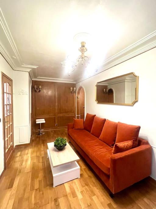 - un salon avec un canapé orange et une table dans l'établissement Incroyable appartement parisien - Batignolles, à Paris