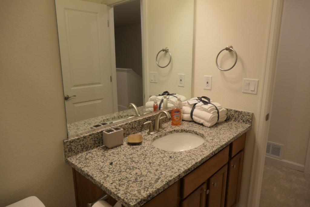 a bathroom counter with a sink and a mirror at Well Appointed 3-Bedroom Townhome in Colorado Springs