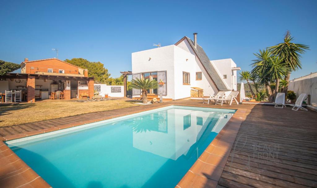 a swimming pool in front of a house at R138 Casa Jessy con gran jardin, piscina y AC in Calafell