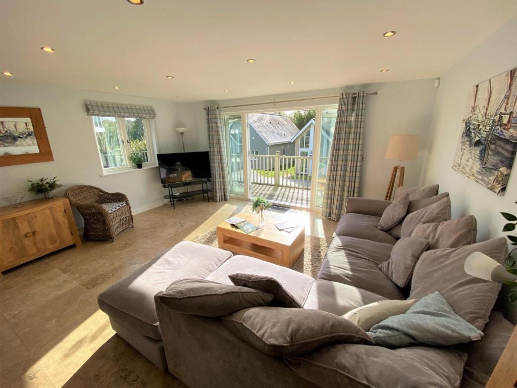 ein Wohnzimmer mit einem Sofa und einem Tisch in der Unterkunft Trewhiddle Villa 29 in St Austell