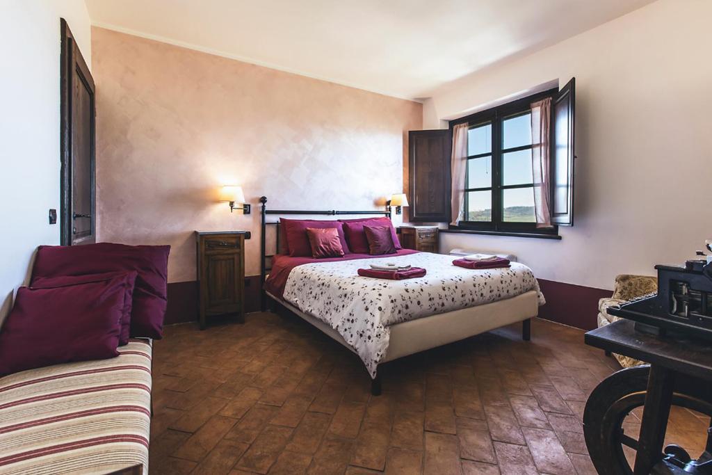 una camera con letto e divano di Casale Le Civette a Montepulciano