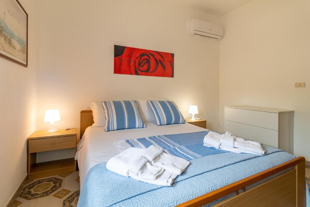 een slaapkamer met een bed met handdoeken erop bij Villetta Kennedy in Ispica